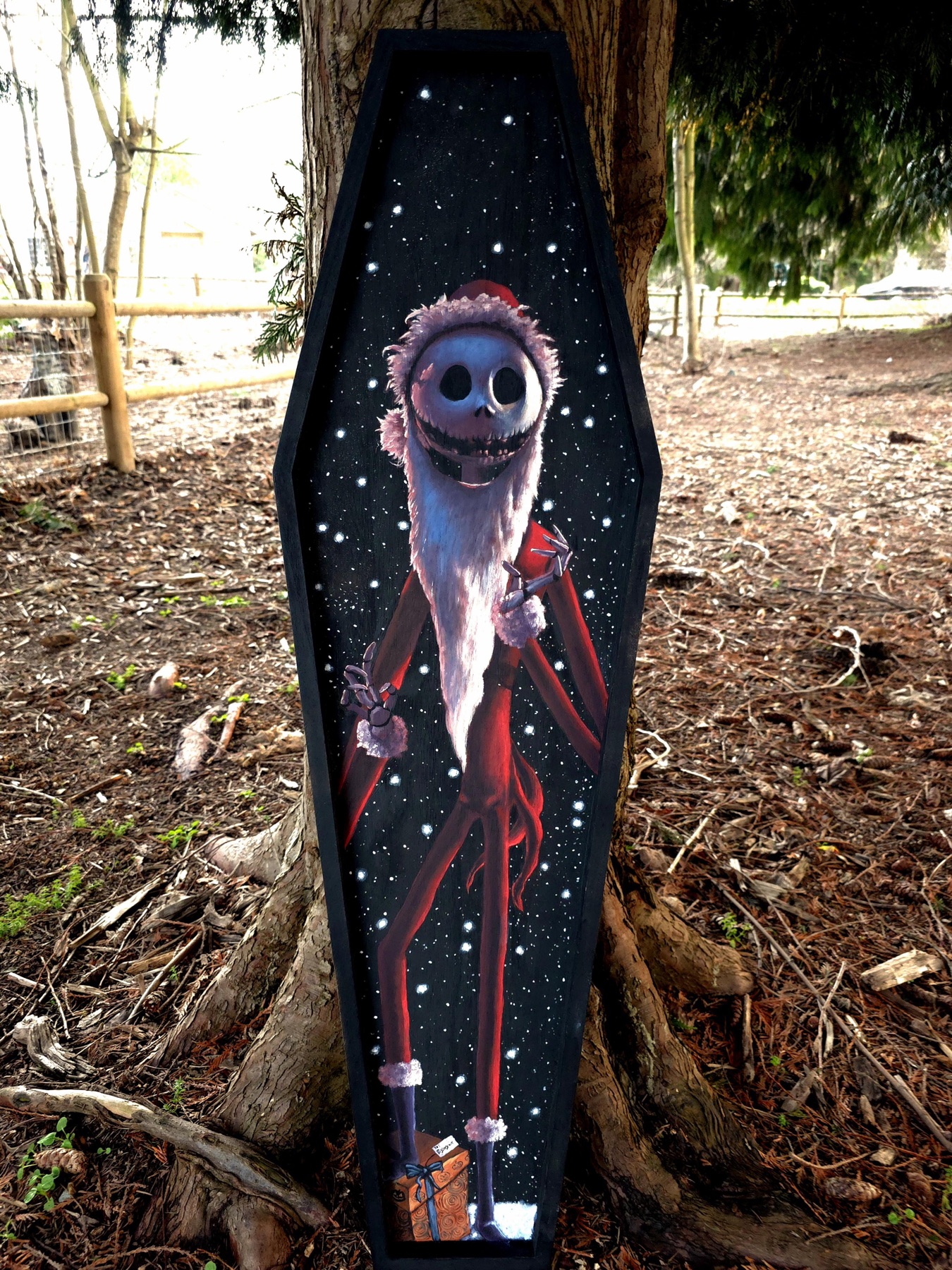 Sandy Claws coffin painting with red starry details outdoors