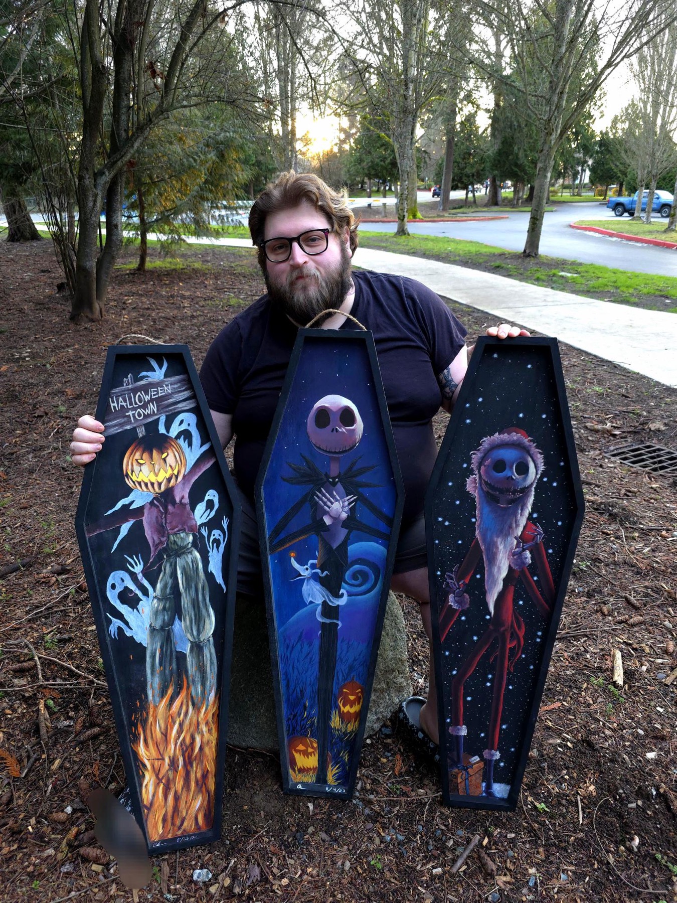 Bigsexy Art holding three Jack Skellington coffin showpieces outdoors