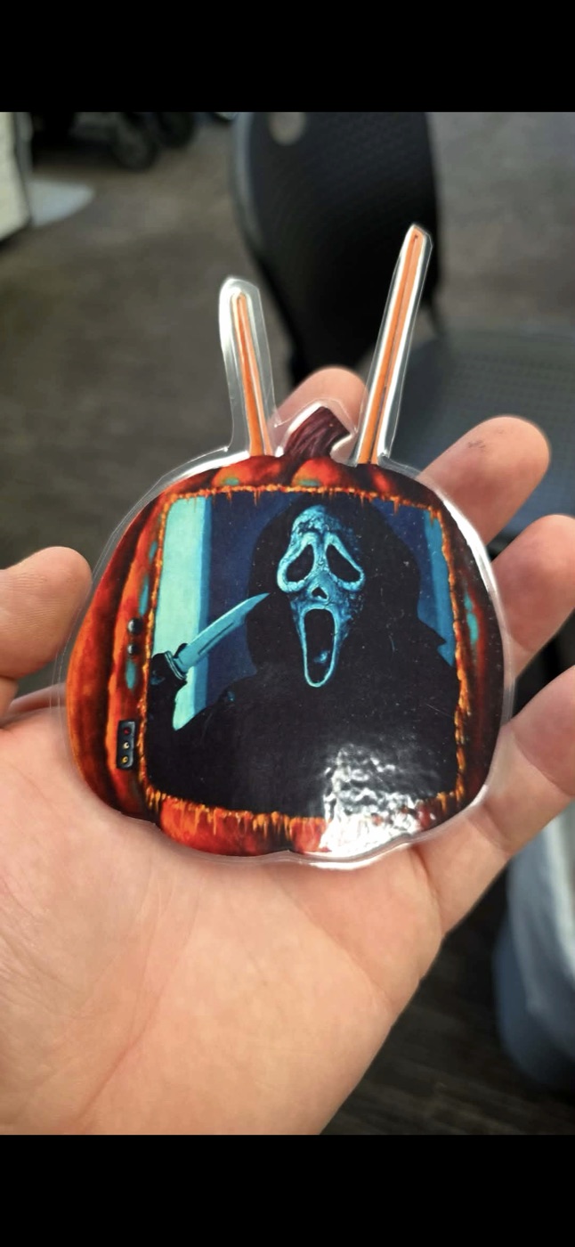 Small rounded Ghostface-style mini print held in a hand