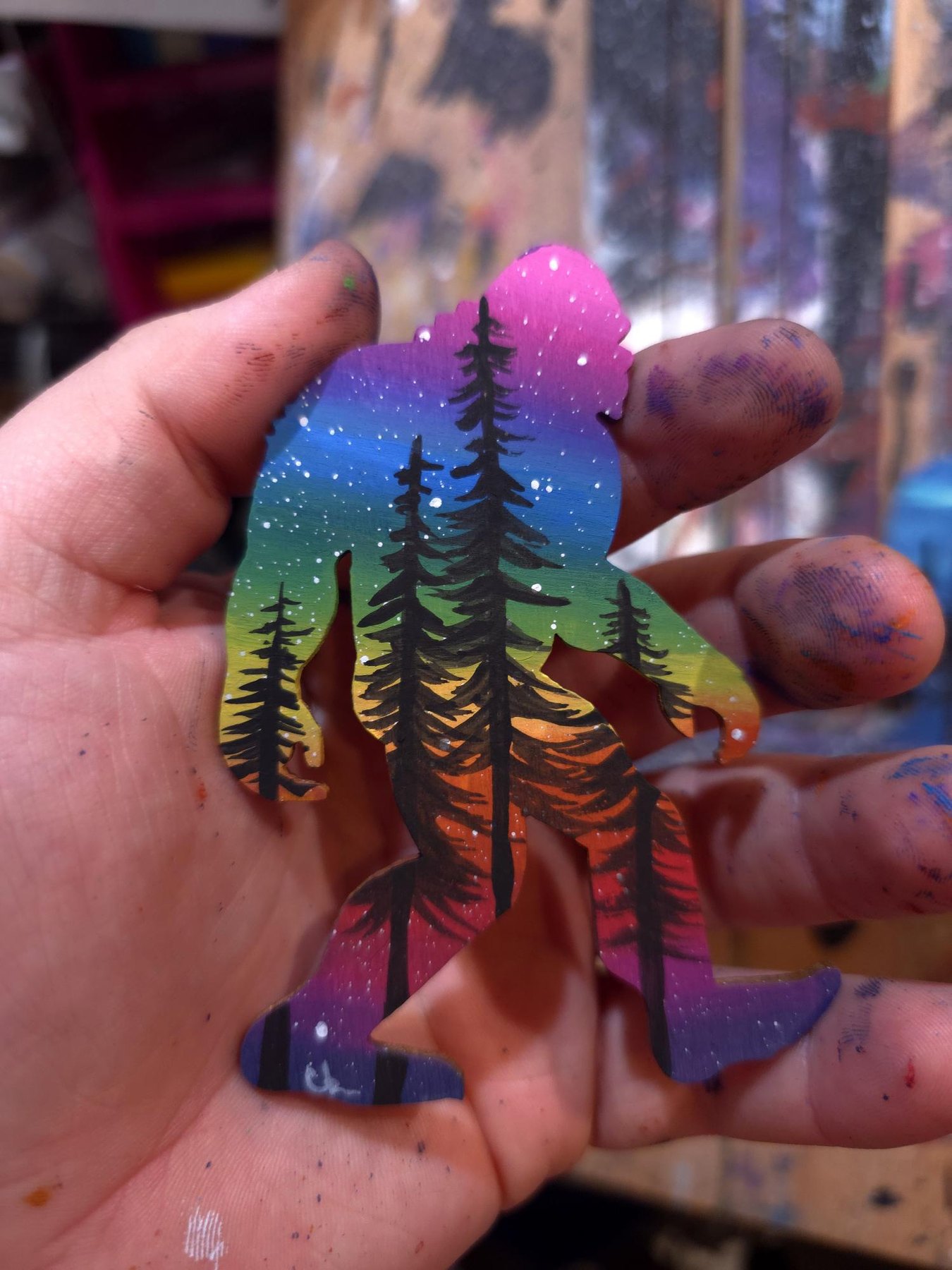Rainbow made-to-order Sasquatch with pine tree silhouettes and bright sunset colors